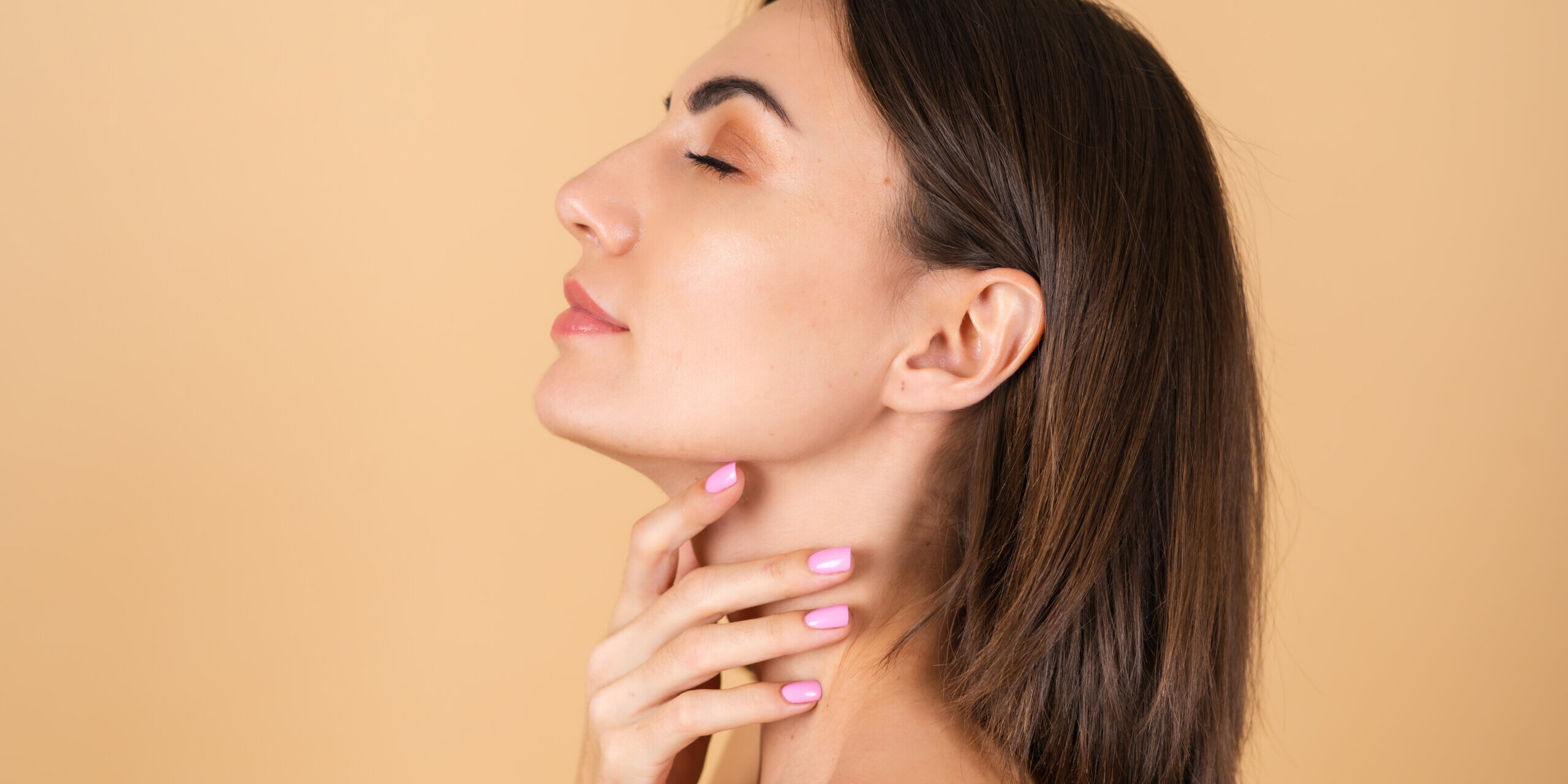 Portrait of a young girl on a beige background with natural makeup, with a light sensual smile, bare shoulders, beauty face, advertising of cosmetics and care